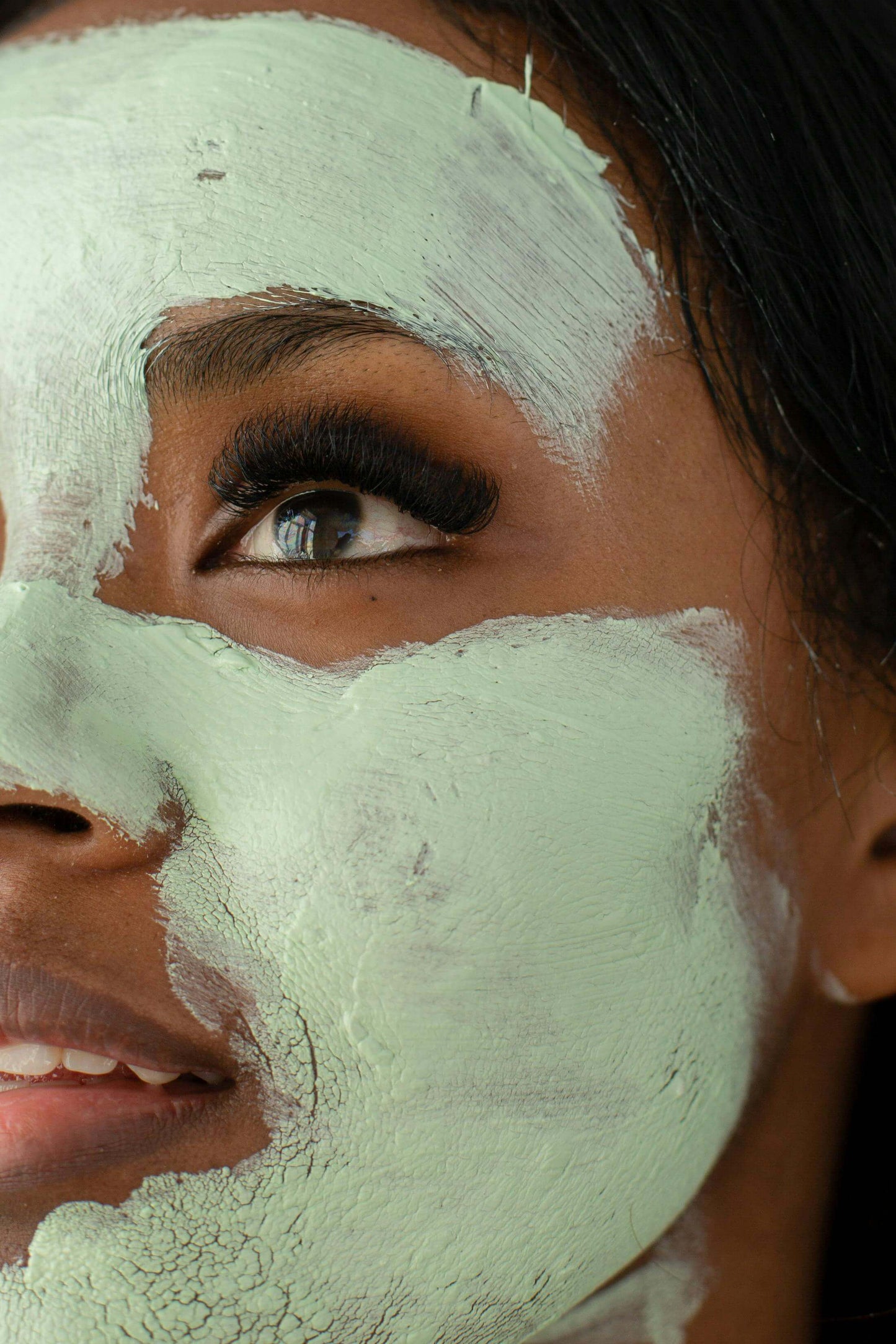 Woman with moisturizing mask on face showcasing skincare benefits.